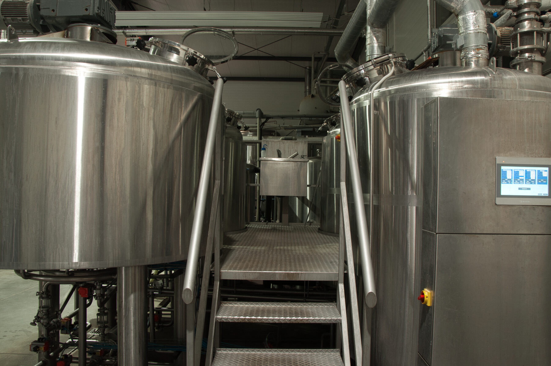 Zbiorniki procesowe z panelem sterowania w zakładzie produkcyjnym